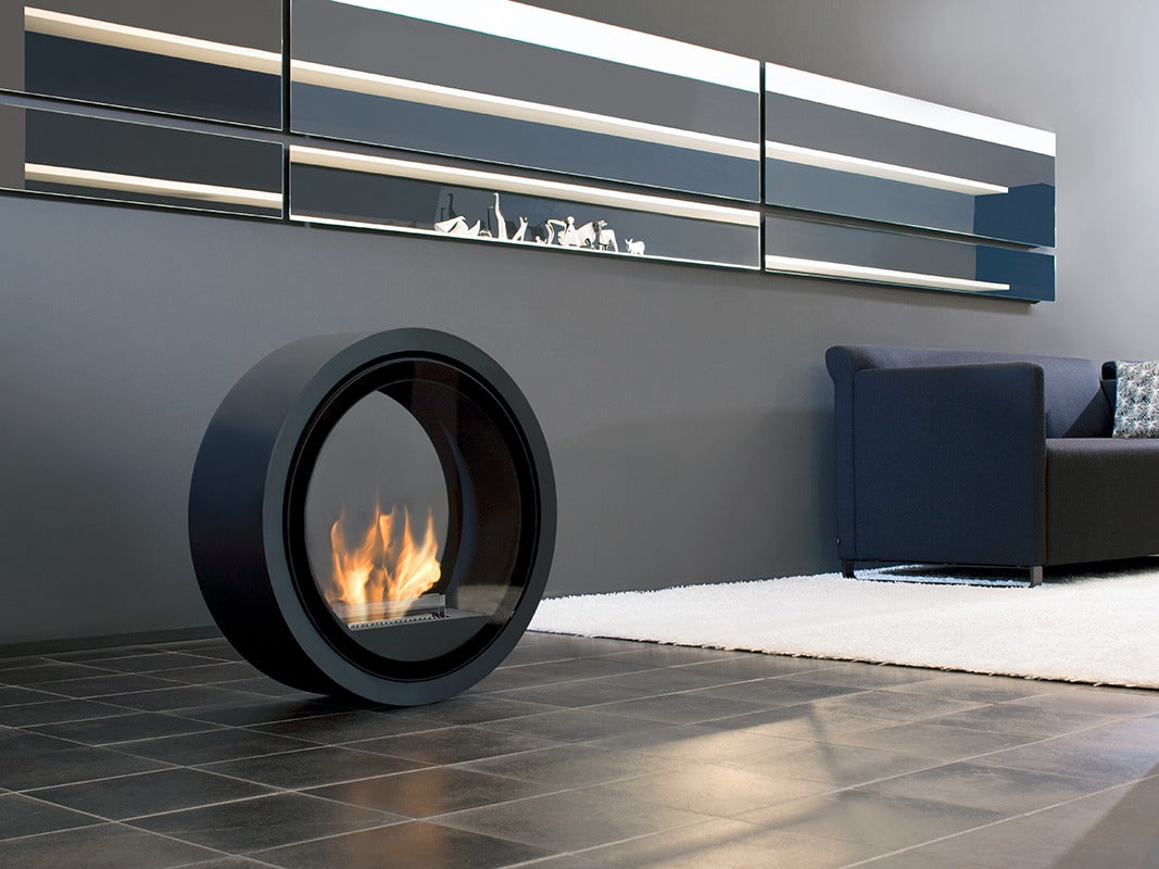 Bioethanol Standkamin ROLL FIRE von conmoto in Schwarz mit Flammen auf dem Boden im Wohnzimmer