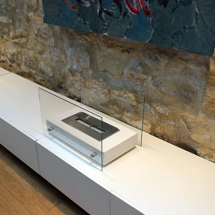 Bioethanol Tischkamin NOVITA auf einem weißen Sideboard vor einer Steinwand