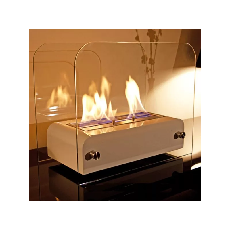Bioethanol Tischkamin TOAST in Schwarz aus Edelstahl mit Glas und Flammen auf reflektierendem Tisch am Abend