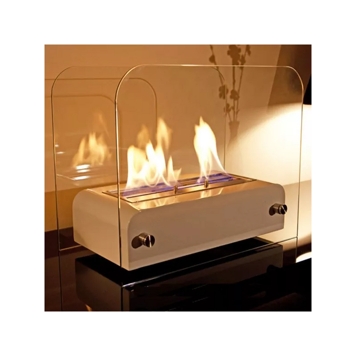 Bioethanol Tischkamin TOAST in Schwarz aus Edelstahl mit Glas und Flammen auf reflektierendem Tisch am Abend