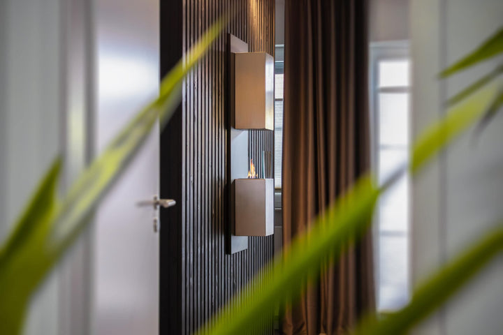 WIKAO Bioethanol Wandkamin KAPTUR in Schwarz mit Glas, seitlich an einer Holzwand im Wohnzimmer