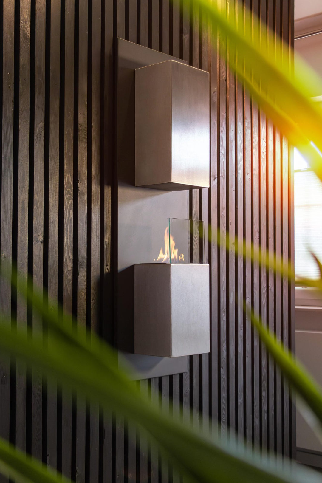 WIKAO Bioethanol Wandkamin KAPTUR in Schwarz mit Glas, vertikal an einer Holzwand im Wohnzimmer