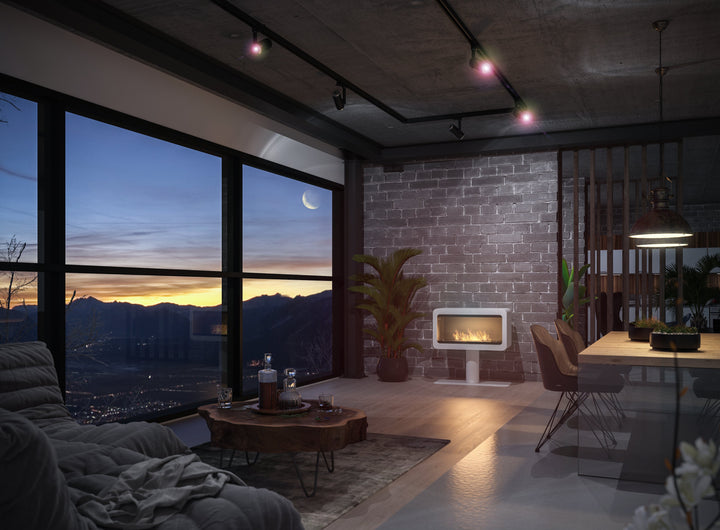 Bioethanol Standkamin INECCO in Weiß in einem Loft mit Panoramafenster bei Abenddämmerung
