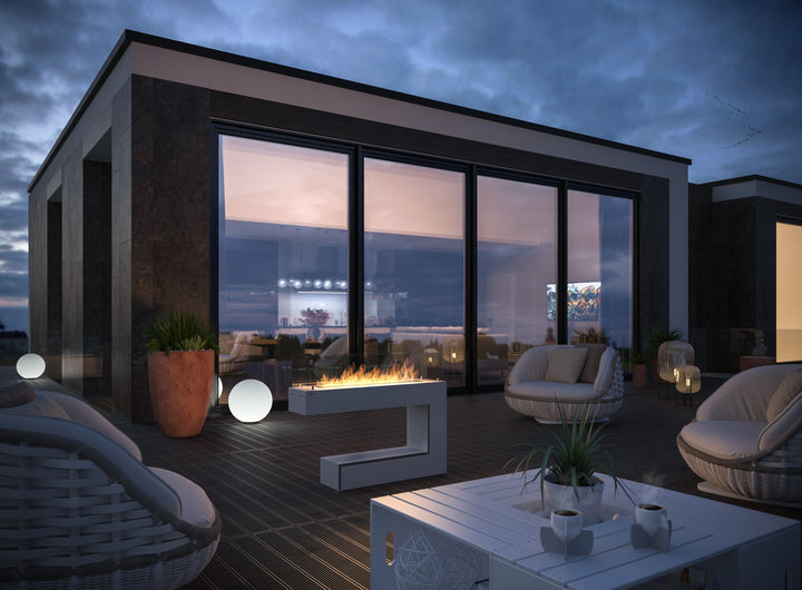Bioethanol Standkamin SPECTRUM in Weiß mit Flammen auf einer Dachterrasse bei Abenddämmerung