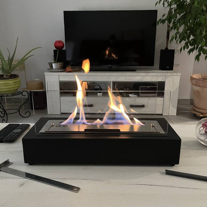 freistehender bioethanol kamin in einem modernen Wohnzimmer. Flammen. Schwarz mit Glas. Tischkamin. Standkamin / Tischfeuer