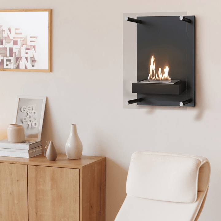 Bioethanol Wandkamin LION V2 in Schwarz an einer hellen Wohnzimmerwand über einer Holzkommode