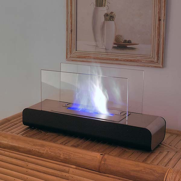 Bioethanol Tischkamin ESTATE in Schwarz mit Glas und Flammen auf einer Holzkommode