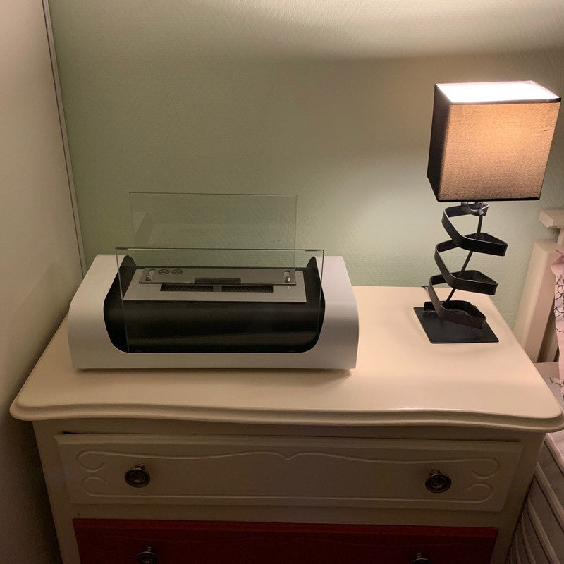 Bioethanol Tischkamin GRENADE in Schwarz mit Glas und Flammen auf einem Nachttisch