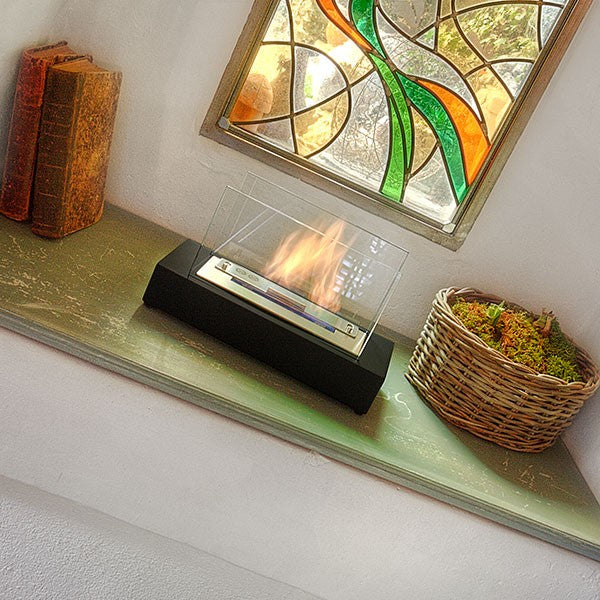 Bioethanol Tischkamin KOBE in Schwarz mit Glas und Flammen, auf einer Fensterbank