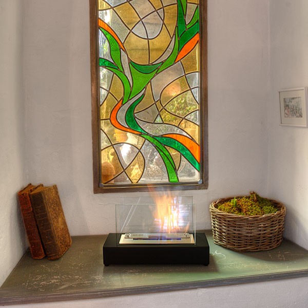 Bioethanol Tischkamin KOBE in Schwarz mit Glas und Flammen, in der Frontansicht, auf einer Fensterbank