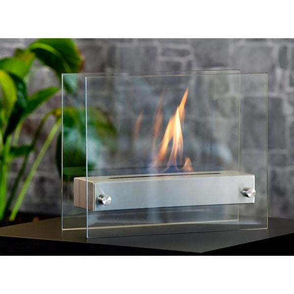 Bioethanol Tischkamin OXY in Schwarz aus Edelstahl mit Glas und Flammen, vor einer Steinwand
